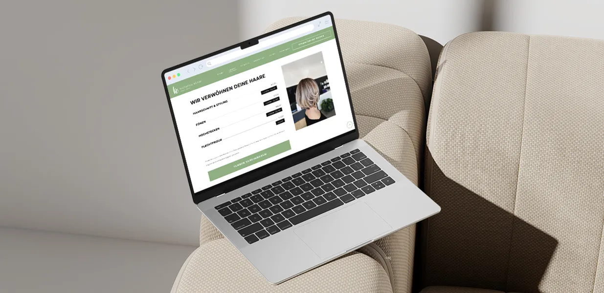 Aufgeklappter Laptop der die Seite eines Friseurladens zeigt